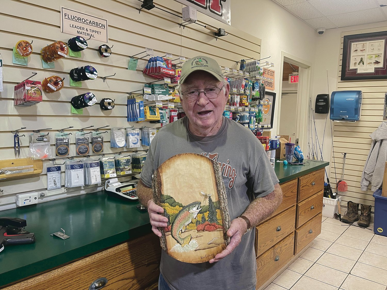 Vic Eckmann pictured with a carving he crafted and now hangs in the Bennett Spring State Park Store.