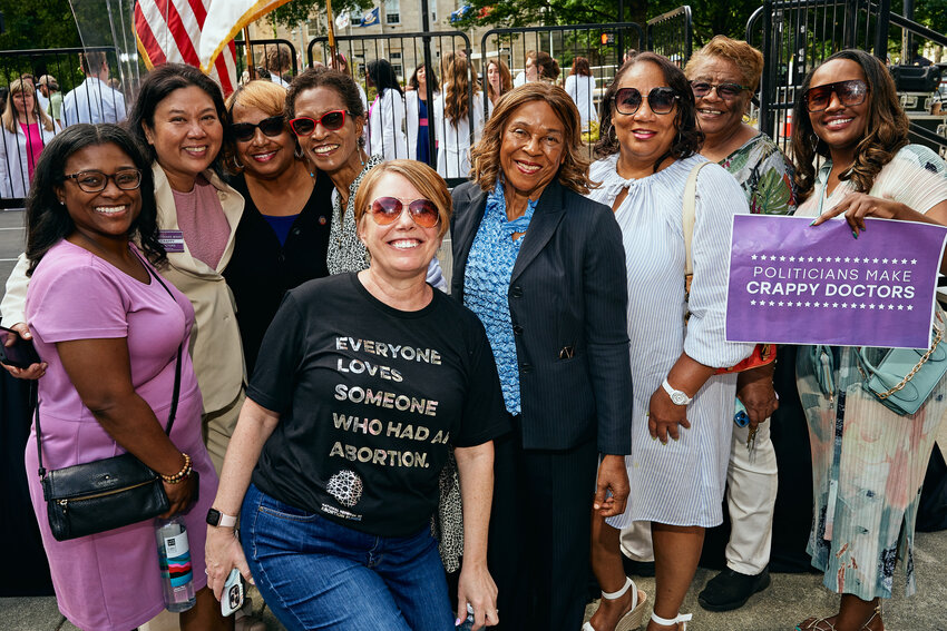 Sen. Natalie Murdock (D-Dist. 20), far right, holds a sign reading 'politicians make crappy doctors' as she poses with doctors, local politicians and other attendees at a rally for reproductive healthcare in downtown Raleigh Saturday.