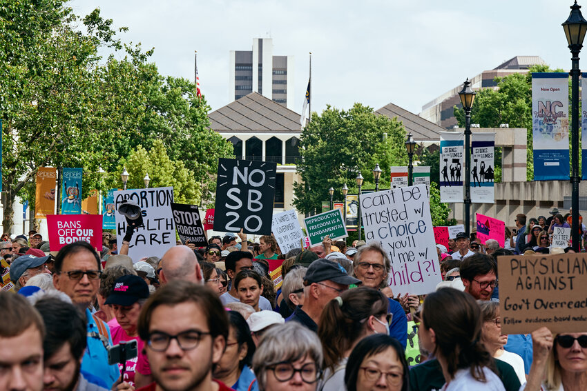Signs reading 'No SB 20,' 'Abortion is health care,' and 'Bans off our bodies' were on full display at a protest for reprodcutive health in downtown Raleigh Saturday. Gov. Roy Cooper officially vetoed S.B. 20 in front of the crowd.