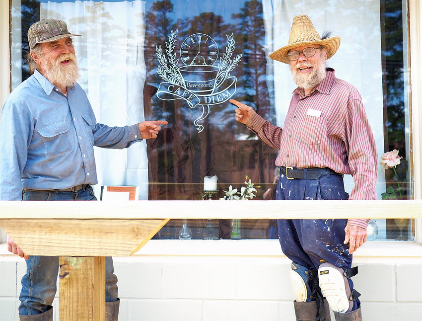 RECLAIMING SPACES IN PITTSBORO Ralph 'Screech' Swager (left) of Moncure and Snuffy Smith of Pittsboro show off the new sign for Davenport's Cafe Diem. The old restaurant is one of several spaces that are finding new purpose in Pittsboro. The town's quirky and creative atmosphere attracts people and businesses that can innovate and see beyond a building's past lives and breath new life into it. The News + Record visited downtown Pittsboro to highlight just some of the reclaimed spaces in Pittsboro..See photo essay, pages B4-B5.