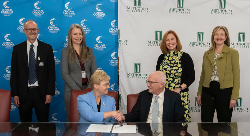 Seated, Central Carolina Community College President Lisa M. Chapman, left, and Methodist University President Stanley T. Wearden with, standing L to R, Don Miller, CCCC Associate Dean of Advising and College Transfer; Kristi Short, CCCC Vice President/Chief Academic Officer; Suzanne Blum Malley, Methodist Provost and Keri Walters, Methodist Associate Provost for Student Success.