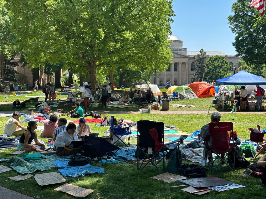 Students work on assignments and listen to organizers as they sit inside the encampment protest in Polk Place at UNC Chapel Hill on Monday, ahead of a police sweep of the encampment Tuesday morning.