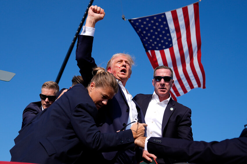 Republican presidential candidate former President Donald Trump is surrounded by U.S. Secret Service agents at a campaign rally, Saturday, July 13, 2024, in Butler, Pa.