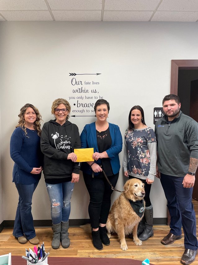Pictured, from left, are Mandy Wigren, Stephanie Graham, Roz Kindell, Terrah Johnson, and Zack Soulliere and Trigger. The 11,400 donation was given to the Northern Michigan Alliance for Children on Thursday, Dec. 30.