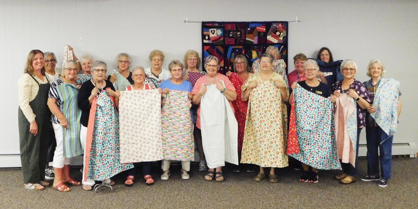 Eighteen members of the Clare County Crazy Quilters are joined by their July 17 guest speaker Keri Withers as they proudly hold up the lap quilt tops they&rsquo;ve sewn with the intent to donate them to children who can benefit from the comfort they provide.