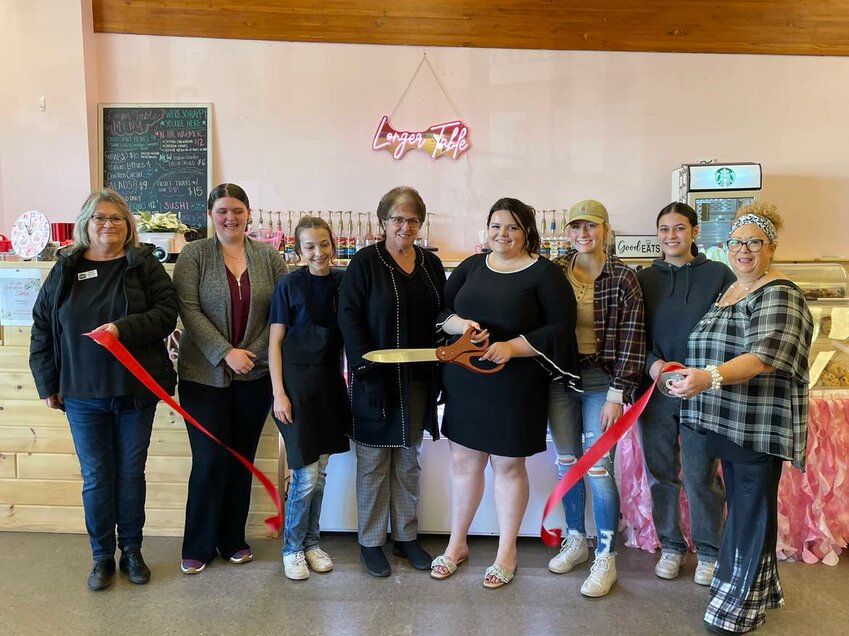 Tammy and Trisha Galloway, owners of Longer Table are joined by their staff and the Harrison Area Chamber of Commerce for a ribbon-cutting ceremony held Saturday, Nov. 18 to celebrate their business&rsquo;s grand reopening.