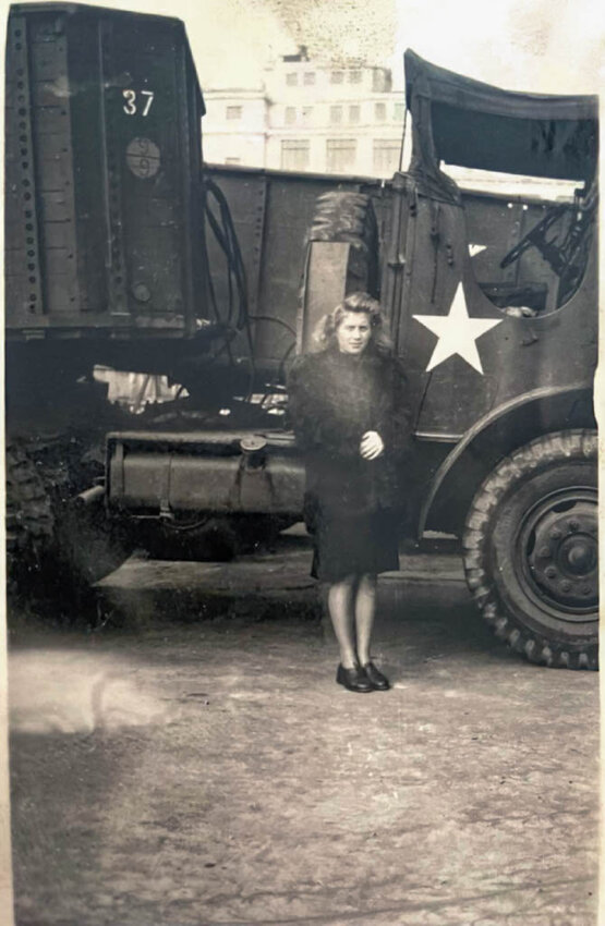 Paulette Zurecki Sharp stands in front of an Army truck in 1945.