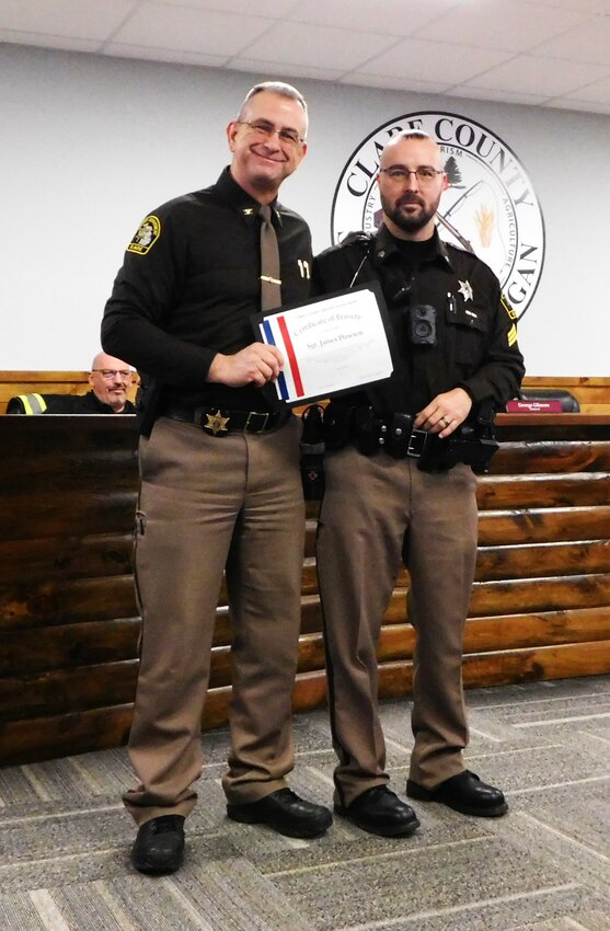 Sgt. James Dawson, right, displays his Certificate of Bravery awarded him for his actions to rescue a swounded 12-year-old girl from an active shooter situation last month near Coleman.