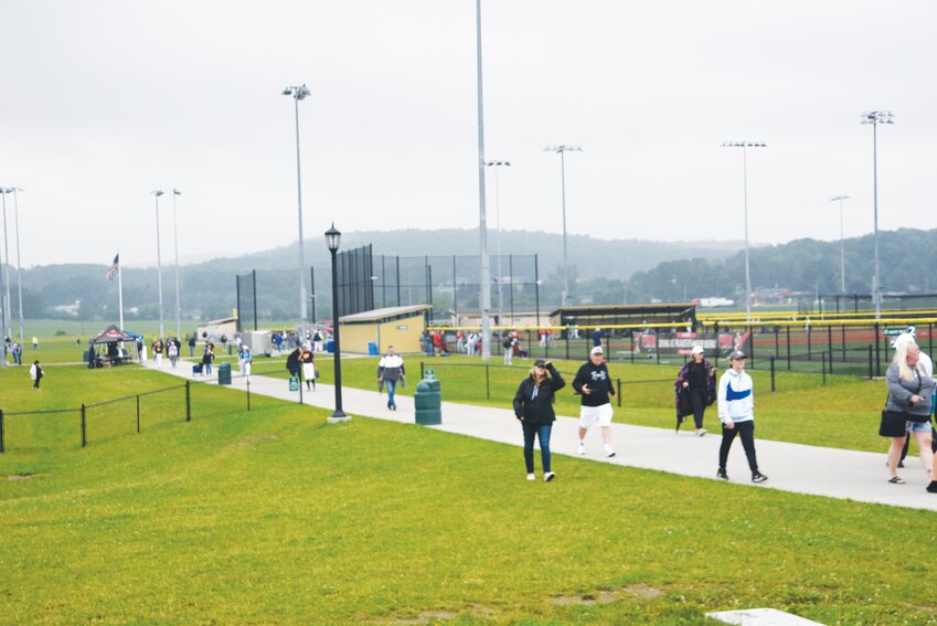 A crowd walks through Gutchess Lumber Sports Complex in Cortlandville in 2023 as Prep Baseball Report teams play behind them. The Cortlandville Town Board has reduced a $6.7 million request for federal money to $3 million to fund parking and event facilities at the complex.