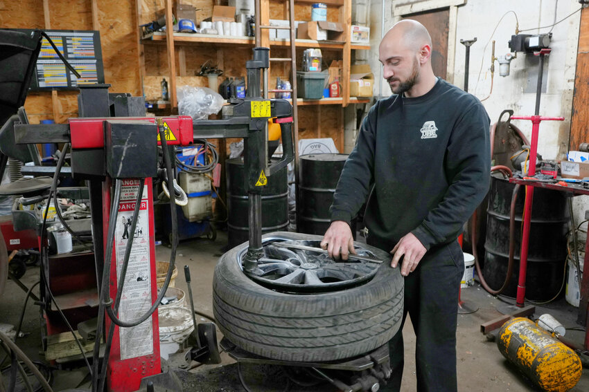 Jared Ellesworth, auto technician at O'Shea Tire & Service Center in Cortlandville, changes tires for a client. Around this time of year, he said he's constantly changing tires for winter weather.