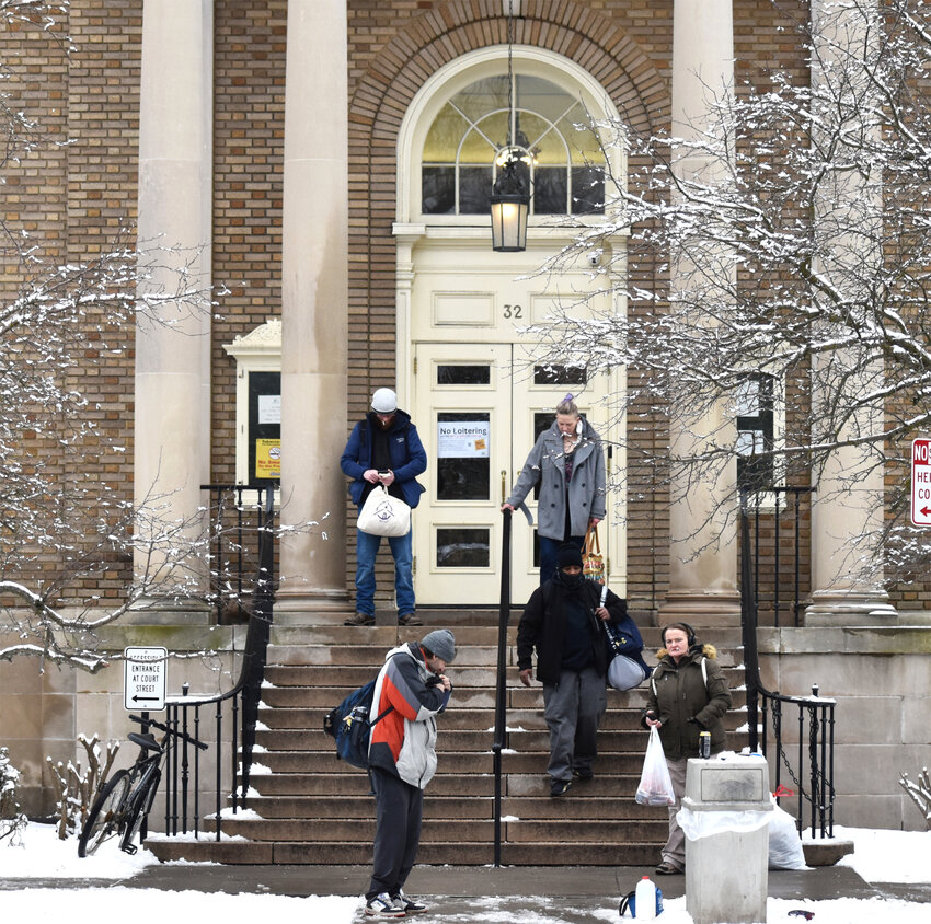 Patrons mill about the entrance of the Cortland Free Library in January, at the center of debate of how to alleviate homelessness in Cortland. The library has enacted new rules that homeless people says makes them feel unwelcome at the facility.