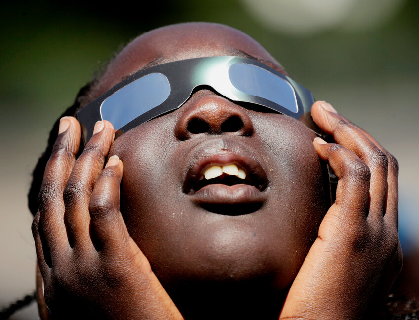 Poureal Long, a fourth grader at Clardy Elementary School in Kansas City, Mo., practices the proper use of eclipse glasses in anticipation of a 2017 solar eclipse. A number of events in the greater Cortland area will herald Monday's eclipse.