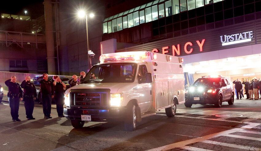 Transport ambulances carry the bodies of two slain officers to the Wally Howard Forensics Science Center in Syracuse early Monday morning. Police officers from several local agencies gathered at Upstate hospital's emergency room to hear the news of two slain officers.
