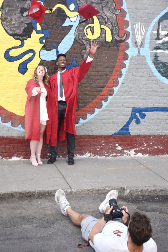 T.J. Pilewski takes photos Thursday afternoon on Clayton Avenue in Cortland of SUNY Cortland seniors Victoria Obar of Middlebury, Connecticut, and Christian Crews of Merick, Long Island. Graduation is in a week. 