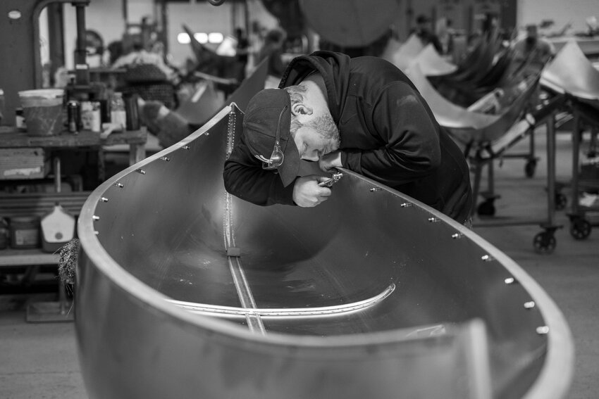 Greg Kiernan installs Cleco fasteners to secure the gunwales before riveting. A typical canoe requires more than 1,400 rivets. Assemblies are done by hand.