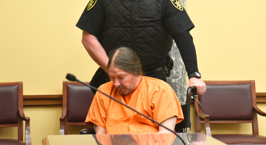 Steven Burda is escorted from a court appearance Friday. He is accused of trying to shoot and kill police during an eviction. Public Defender Kevin Jones asked the presiding judge to seal certain evidence.