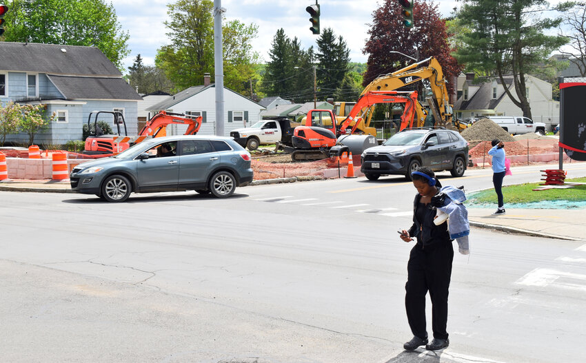 Madison Hodges of Harlem checks her phone Thursday as she crosses Broadway in Cortland. The soon-to-be geographic information systems graduate won't be around when the street closes Monday until July 5 for an overhaul that includes raised sidewalks and turning lanes.