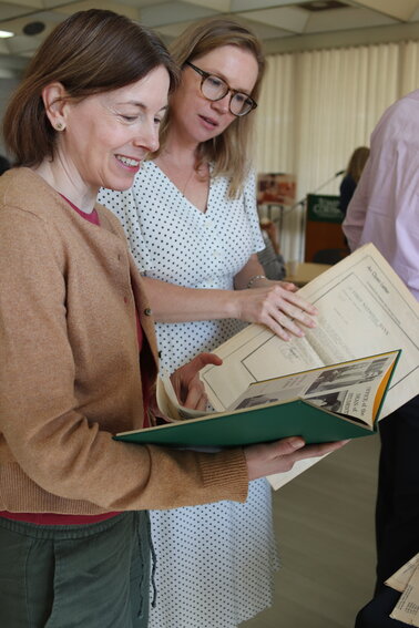 Victoria Zeppelin, director of CollegeNow at Tompkins Cortland Community College, and Merryn Clay, coordinator of global partnerships and programs, look over an old college yearbook and an edition of the student newspaper at an event Monday marking the college's 50th anniversary on the Dryden campus.