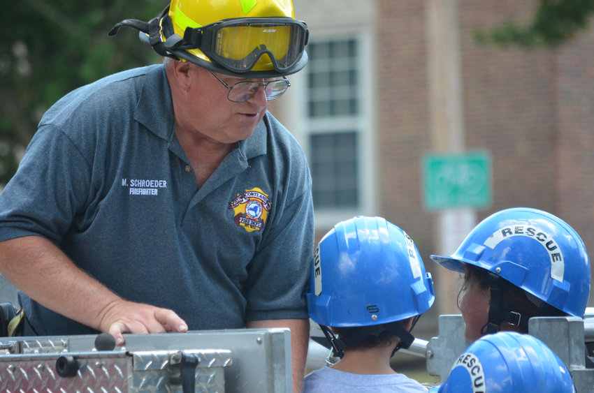 Cortland Firefighter Mark Schroeder brings kids onto the aerial ladder at Firefighter for a Day camp in 2022 at Suggett Park in Cortland. Registration is open for this year's camp.