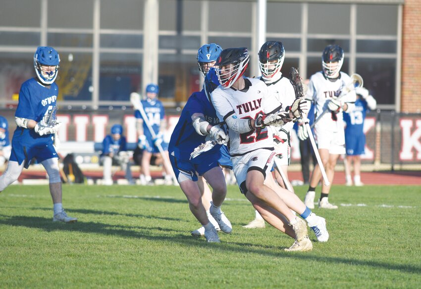 Tully/F-P's Jake Verbanic, center, makes a move to get past an Oswego defender Tuesday night at Tully High School. Verbanic went for six goals and two assists in the Black Knights' 20-7 win.