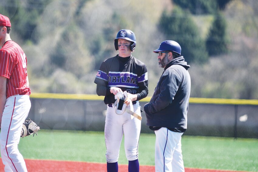 Cortland’s Caden Albright, center, talks to first base coach Abe Johnson, right, after hitting a single Monday at Gutchess Lumber Sports Complex. Albright broke the school’s career hits record and had his 100th career hit in the Purple Tigers’ 3-1 loss.
