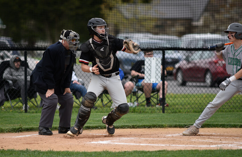 Tully's Will Lund, center, pops out of his squat to throw out a potential base stealer Thursday at Tully High School.