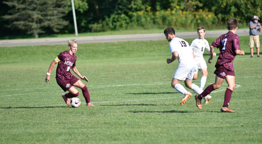 McGraw's Logan Moffitt, left, looks to attack Mater Dei's Timothy Burns, center, while possessing the ball Wednesday at Elm St. Field. Moffitt scored the Eagles' lone goal in a 5-1 loss.