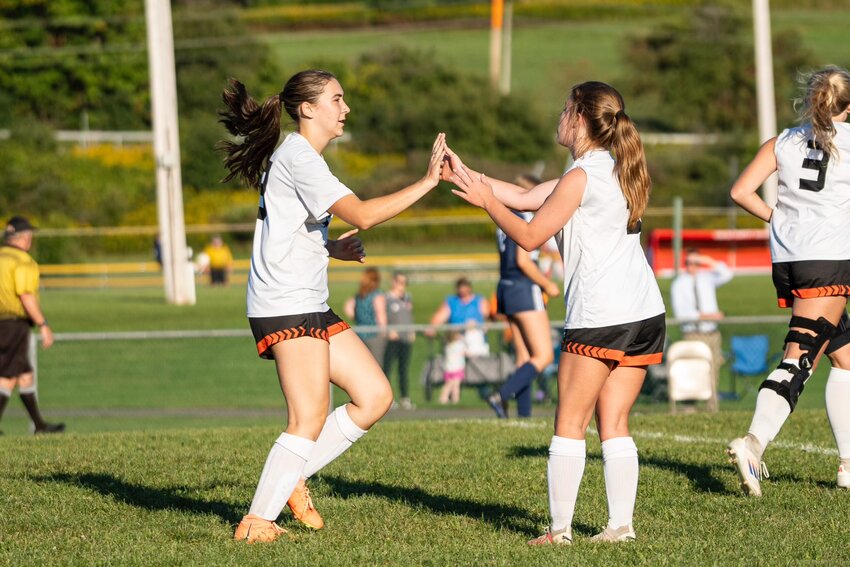 Marathon’s Megan Stewart, left, goes to high five Zoey Gleason following a goal against Jordan-Elbridge Thursday at Fabius-Pompey Jr./Sr.  High School. Stewart had a goal and Gleason had an assist in the Olympians’ 2-0 win.