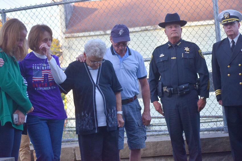 The family of retired Trooper Steve Bilodeau -- including his daughter, Theresa Covell, wife Sharon Bilodeau and mother Dorothy Bilodeau -- stands Wednesday at the First Responders Memorial in McGraw as Taps is played at a 9/11 ceremony. Bilodeau died last month of health complications stemming from the seven weeks he spent at Ground Zero.