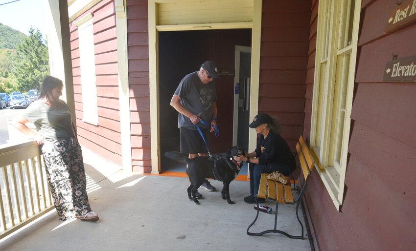 Amy Bertini of Homer, right, pets a dog being walked at Dwyer Memorial Park in Preble. Bertini and Samantha Hodge, left, volunteer at Cortland Repertory Theatre, which has shows at the pavilion at the park during warmer months.