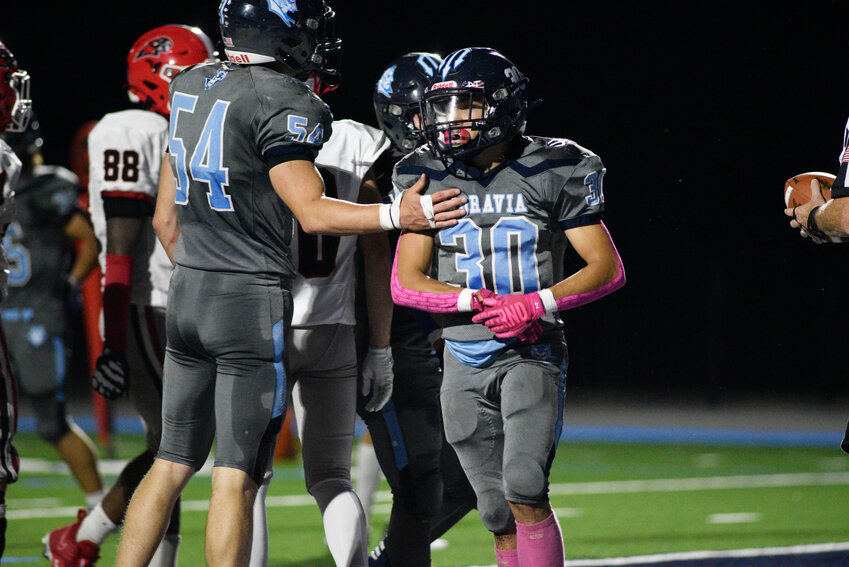 Moravia's Hunter Boynton, center, is tapped on the chest by teammate Ethan Dehart after scoring a touchdown Friday night at Scarry Athletic Complex.