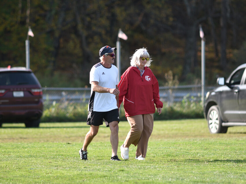 Former Cincinnatus head coach Gordy Brown, left, and his wife Kimberly Brown walk to the center of the field Thursday at Fireman's Field.