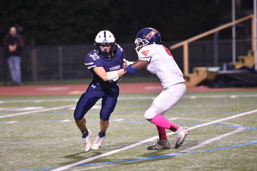 Homer's Hunter Lines, left, looks to get around a block from an Institute of Technology offensive player Friday night at Homer High School.