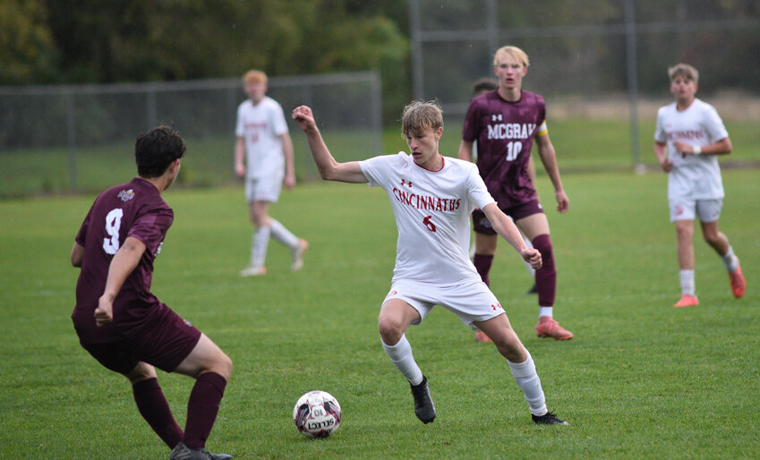 Cincinnatus' John Schuyler, center, makes a move to get past McGraw's Liam Baker, left, Wednesday at Bennett St. Field. Schuyler scored in the first half of the Lions' 2-0 win.