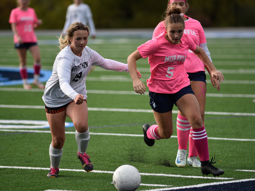 Moravia's Cece Stryker, right, works past a Marathon defender Thursday at Scarry Athletic Complex. Stryker scored a hat trick in the Blue Devils' 3-1 win.