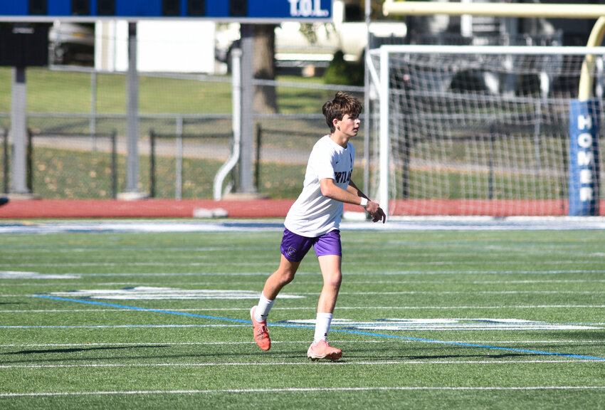 Cortland's Tristan Milligan follows through after sending a ball up the field Saturday at Homer High School. Milligan scored the deciding goal in the Purple Tigers' 2-0 win.