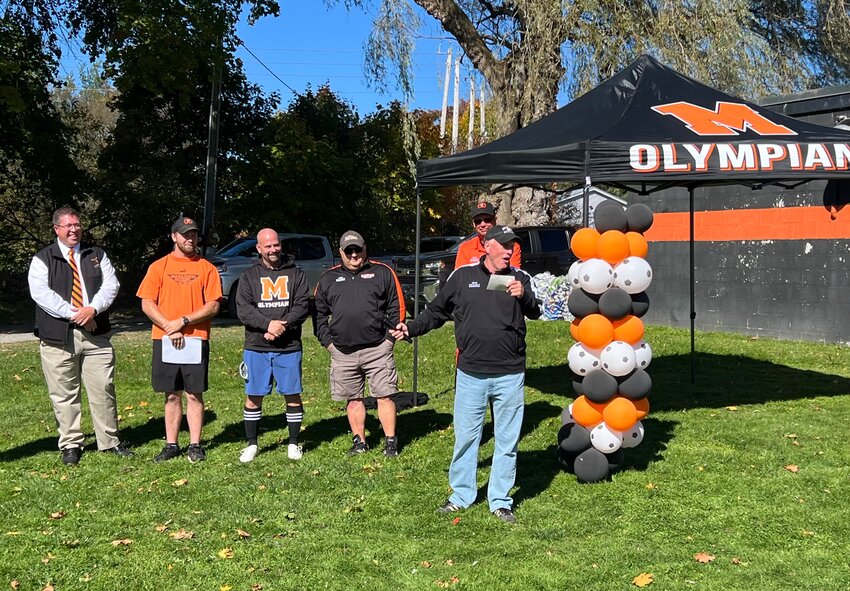 Chip Stewart, front, addresses the crowd at Stewart Field Saturday. Marathon named the soccer field at the high school after its longtime coach.