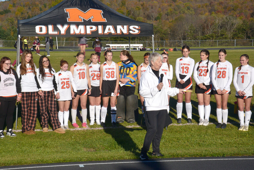 Marathon head coach Karen Funk speaks to the crowd with her team behind her during Thursday's field dedication at the newly named Karen Funk Field.