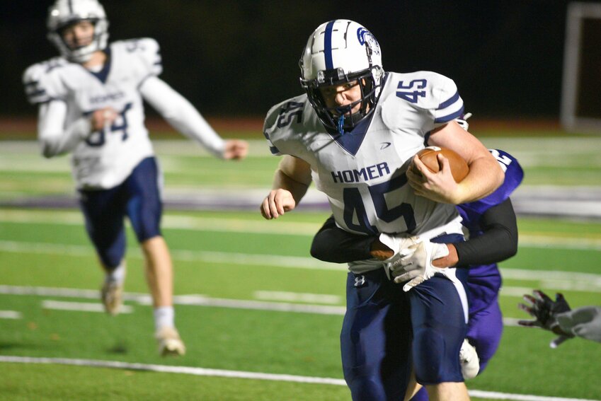 Homer’s Alex Votra runs through a Cortland tackle Friday night at Cortland Jr./Sr. High School. Votra finished with 277 rushing yards and five touchdowns in the Trojans’ 58-12 win.