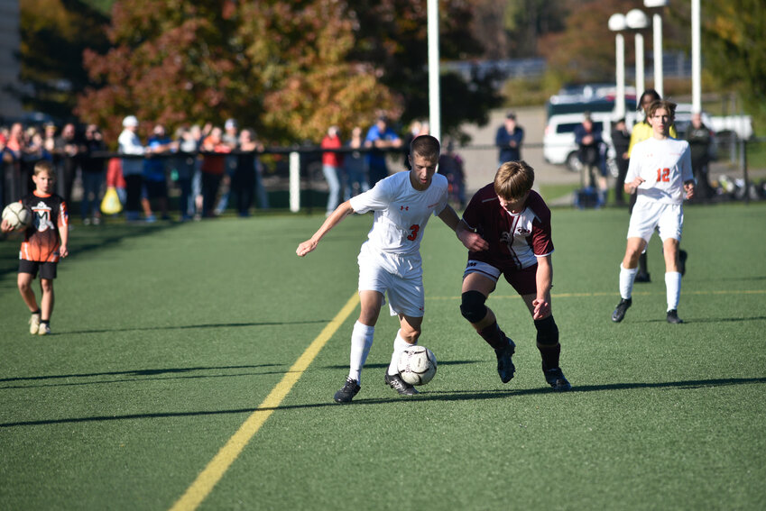 Marathon's Colton Oram, left, looks to get past an Odessa-Montour defender Saturday at Tompkins Cortland Community College. Oram scored once and tacked on an assist in the Olympians' 4-0 win.