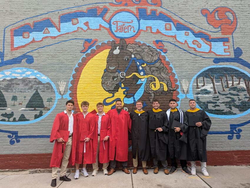 SUNY Cortland students pose in front of the Dark Horse Tavern mural Wednesday.