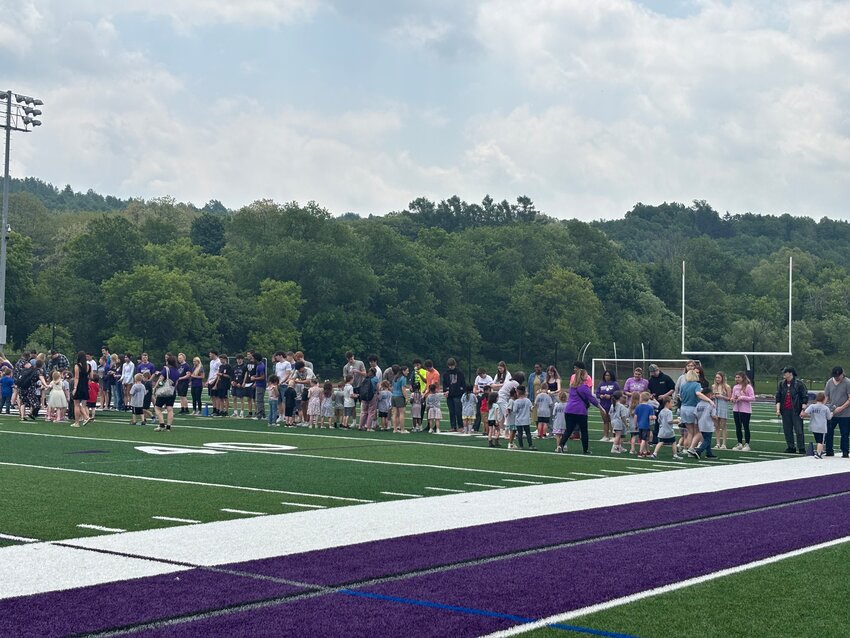 The kindergarteners and seniors line up on either side of the field and meet each other at the 50-yard line.