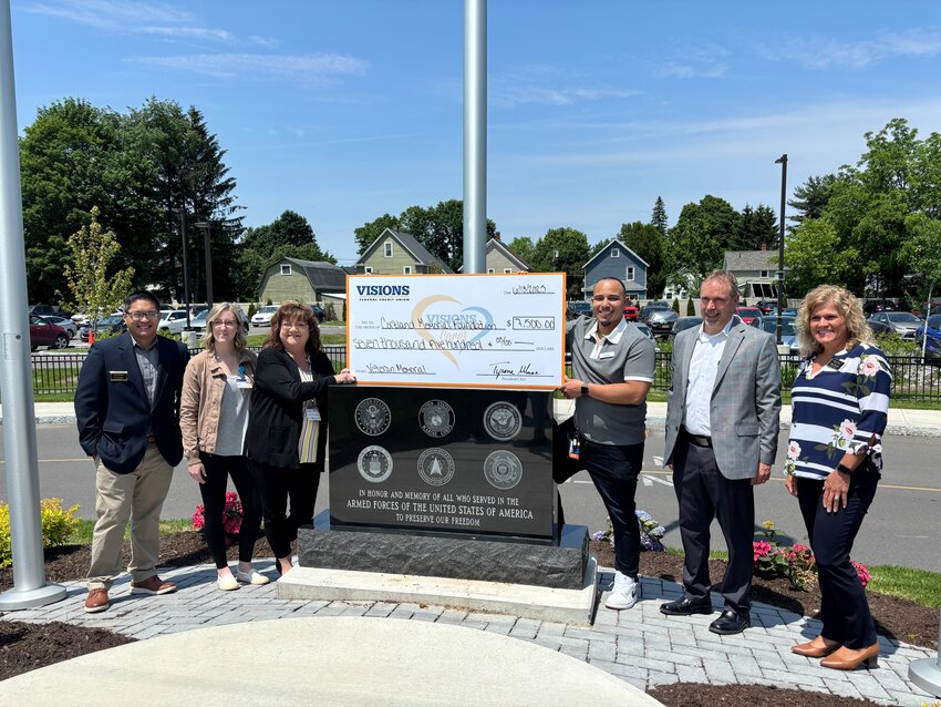 (From left to right) Dr. Rex Gido, Taylor McConnell, Sheila Ossit, James Garcia, Brad Totman and Marie Darling pose with the check from Visions Federal Credit Union at the veterans monument.