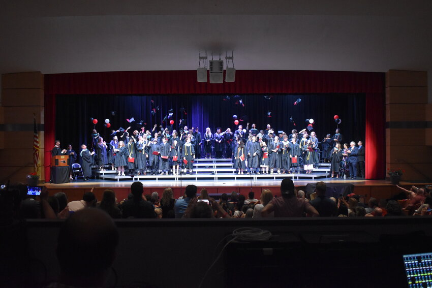 Members of Tully’s Class of 2025 throw their caps in the air Saturday at Tully High School.