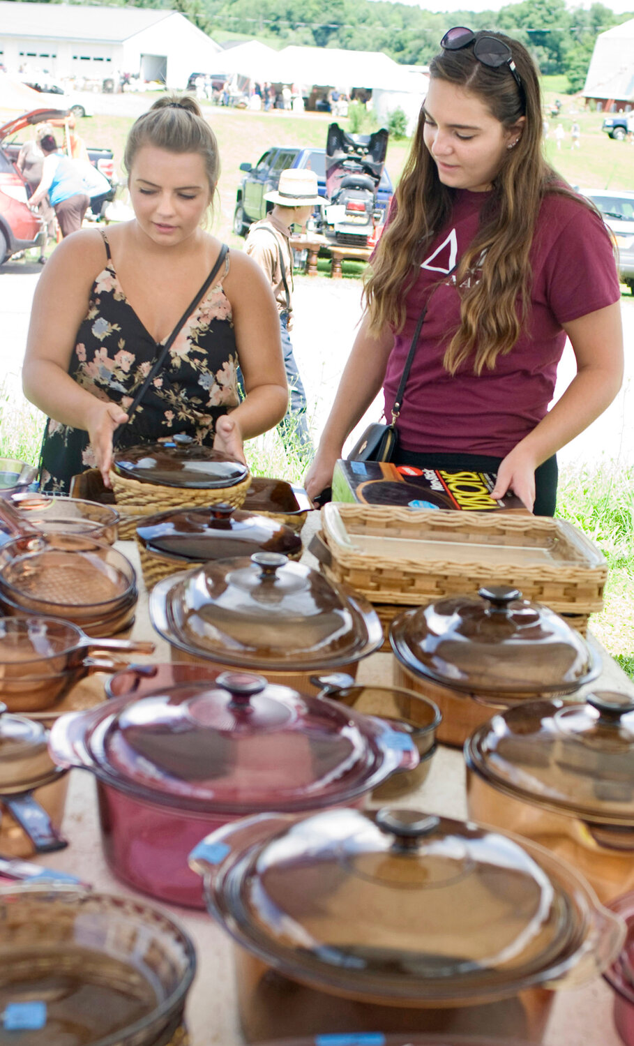 Destany Beebe, left, and Danielle Lynch, right, shop for crockery in 2018 in the Summerhill section of the Route 90 Garage Sale. The event returns this weekend.