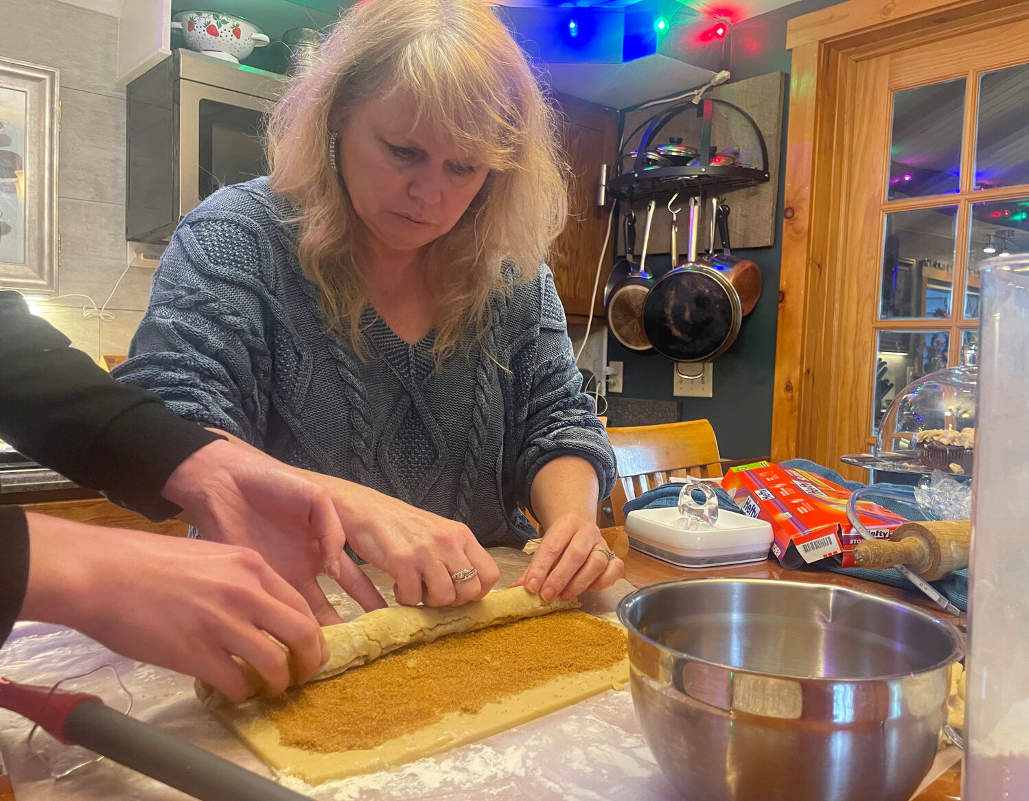 Lisa Byrne rolls the dough for her cinnamon roll cookies, a new addition of the annual Christmas cookies.