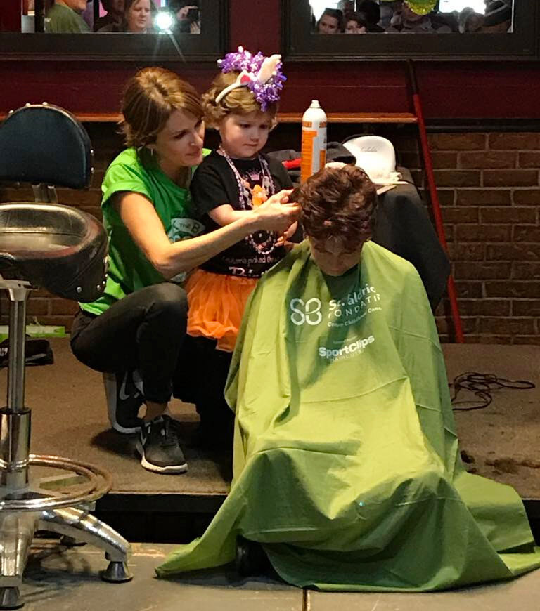 Cancer survivor Alayah Green, then 4, shaves Roxanne Davis' head at St. Baldrick's Day in 2018.