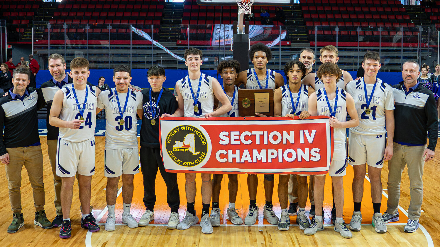 The Dryden boys basketball team poses with the winning plaque and banner after winning the first Section IV Class B title in program history Sunday at Visions Veterans Memorial Arena in Binghamton. The Lions beat Waverly 51-48.