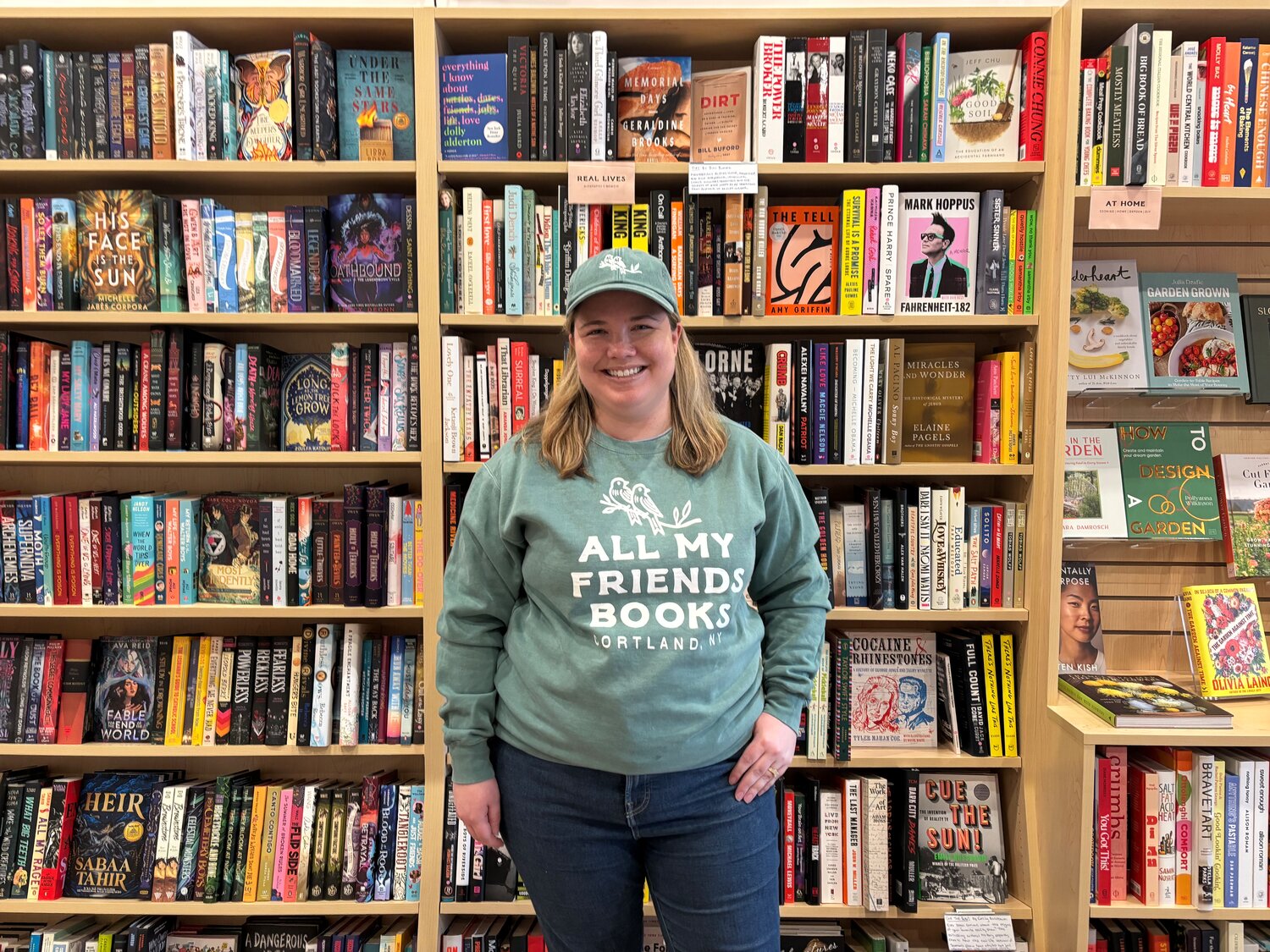 Haley Flannery, owner of All My Friends Books, poses in front of a shelf Friday in her store. All My Friends Books is a new book store on Main Street in Cortland.