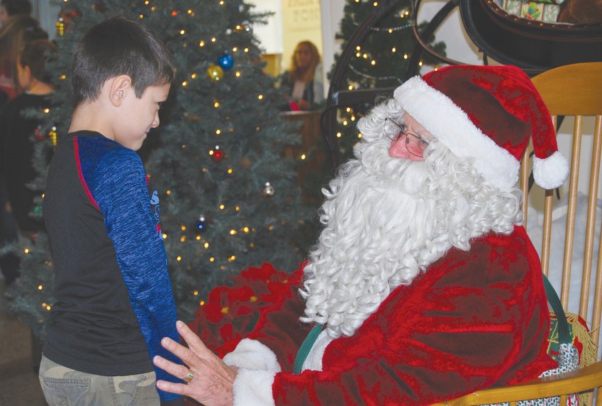 Santa Claus shares a moment with a young boy at the Carnegie Museum on Saturday.